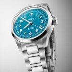 ORIS watch with turquoise dial, oversized crown, and stainless steel bracelet for stylish functionality.