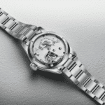 Elegant watch showcasing intricate mechanical movement with polished stainless steel case and exhibition back.
