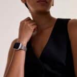 Elegant individual in black attire showcases modern fashion and a stylish smartwatch.