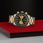 Stylish black and gold chronograph watch with stainless steel bracelet, emphasizing luxury and elegance.
