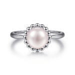 Elegant silver ring featuring a lustrous central pearl in an intricate scalloped setting.