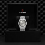 Luxurious Tudor watch in elegant box with polished silver finish and classic Roman numeral dial.