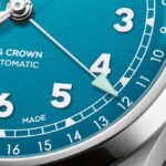 Vibrant teal automatic watch with bold numerals and polished crown, showcasing modern craftsmanship.