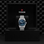 Tudor wristwatch with blue dial in elegant black presentation box, showcasing luxury and craftsmanship.