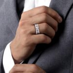 Elegant hand with a modern silver ring, paired with a sophisticated gray suit.