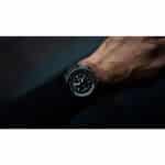 Stylish wristwatch with black face and textured strap, showcasing modern elegance and functionality.