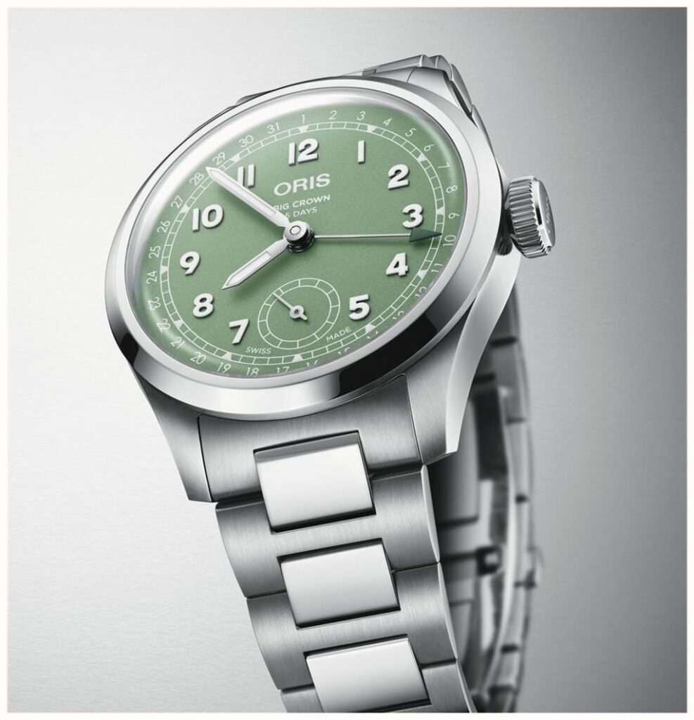 Stylish Oris wristwatch with a green dial, stainless steel case, and brushed metal bracelet.