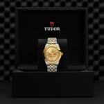 Elegant Tudor watch in luxurious display case, showcasing timeless style and craftsmanship.