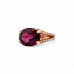 Stunning rose gold ring featuring a large oval purple gemstone and sparkling white diamonds.