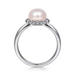Elegant silver ring featuring a lustrous rosy pearl and textured beaded detail.
