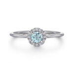 Elegant blue gemstone ring with diamond halo, perfect for engagement or special occasions.