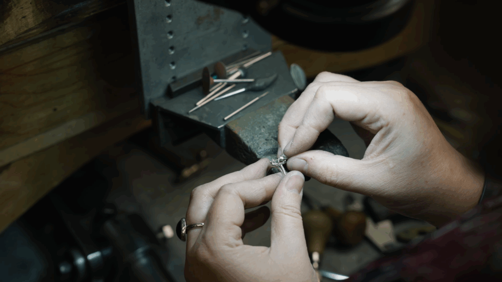 Jewelers hands delicately crafting a ring, showcasing skill and precision in jewelry repair.