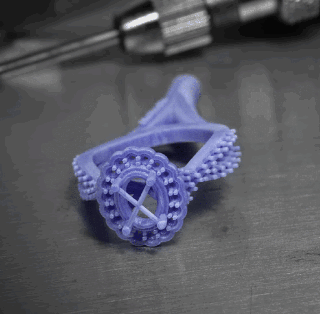 Intricate lavender ring design showcases 3D printing craftsmanship against a metallic backdrop.