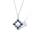 Geometric sapphire pendant necklace with diamond halo, showcasing elegance and timeless charm.