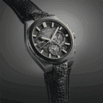 Elegant Seiko Astron watch with black case, gray dial, gold accents, and leather strap.