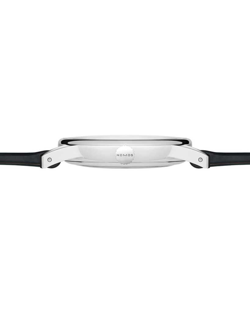 NOMOS minimalist watch featuring polished stainless steel case and leather strap for timeless elegance.