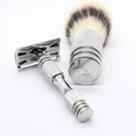 Sleek silver safety razor and shaving brush for a luxurious mens grooming experience.