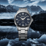 Seiko watch with blue dial against scenic mountains and lake, combining elegance and adventure.