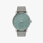Minimalist NOMOS Glashütte watch with a green dial, silver case, and gray leather strap.