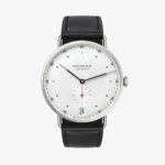NOMOS Glashütte minimalist watch features a white dial, date display, and black leather strap.