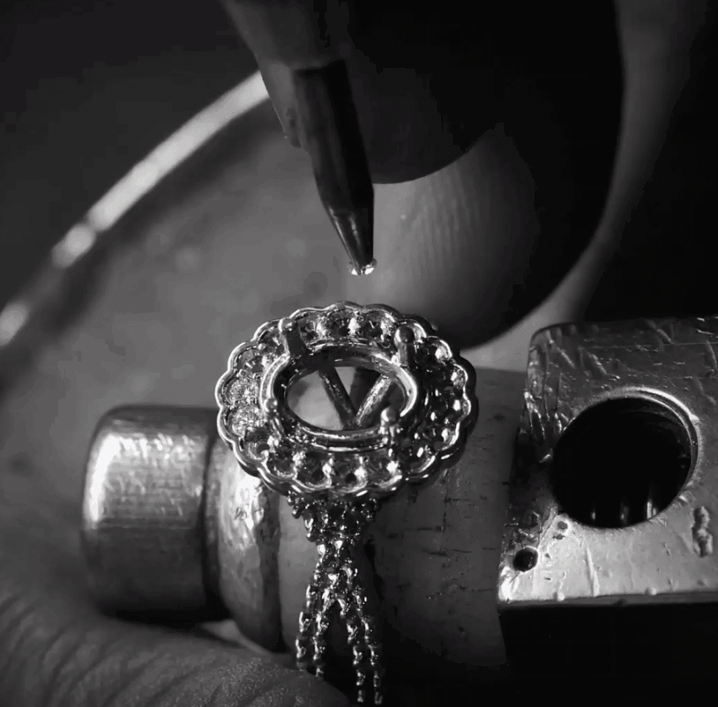 Jeweler crafting intricate silver jewelry with precise tools, showcasing detailed artistry and craftsmanship.