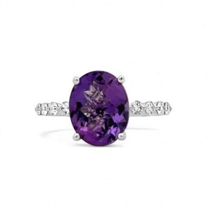 Elegant oval amethyst ring with diamond accents in polished silver band for stunning jewelry collection.