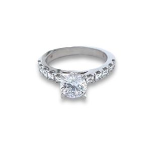 Elegant engagement ring featuring a round-cut diamond with channel-set accents in white gold.