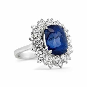 Elegant sapphire cushion cut ring with diamond halo in white gold or platinum setting.