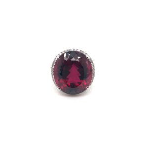 Elegant red ruby ring with diamond halo in white gold, showcasing luxury and craftsmanship.