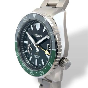 Seiko Spring Drive watch featuring a black dial, green bezel, and stylish stainless steel bracelet.