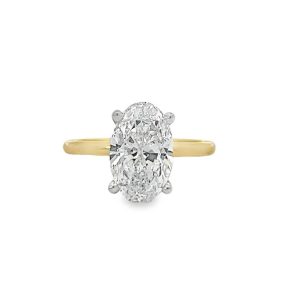 Elegant oval diamond engagement ring in yellow gold and white metal setting for timeless romance.