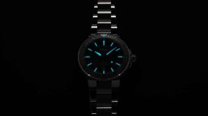 Sleek black wristwatch with luminous blue hands, textured bezel, and polished metal bracelet.