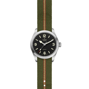 Tudor Ranger watch features a stainless steel case, black dial, and khaki fabric strap.