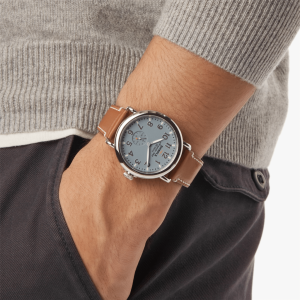 Stylish watch on a wrist with a gray sweater, blending modern and vintage aesthetics.