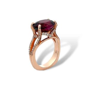 Elegant rose gold ring featuring a brilliant oval red gemstone and shimmering accent diamonds.
