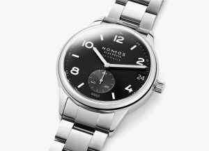 Elegant Nomos Glashütte watch with minimalist black dial, stainless steel case, and interlocking metal bracelet.