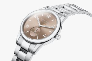 Elegant Nomos watch with polished stainless steel, bronze dial, and precise craftsmanship.