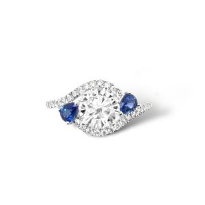 Elegant ring featuring a brilliant round diamond and striking blue sapphires in a classic design.