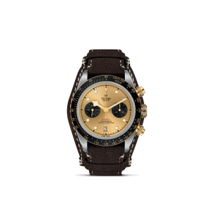 Elegant Tudor watch with gold sunburst dial, chronograph features, and leather strap.