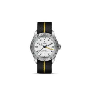 Tudor wristwatch featuring a white dial, rotating bezel, and sporty fabric strap with yellow accents.