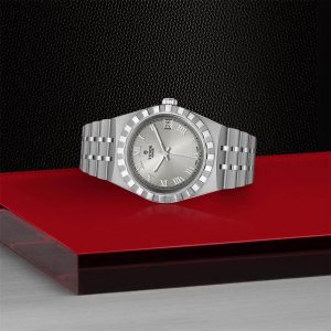 Luxury stainless steel watch on a vibrant red surface, showcasing elegance and timeless craftsmanship.