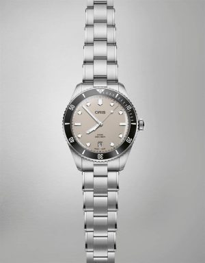 Oris dive watch with stainless steel bracelet, unidirectional bezel, and elegant light gray dial.