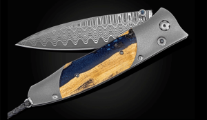 Stunning Damascus folding knife with wood and resin handle, showcasing exquisite craftsmanship and design.