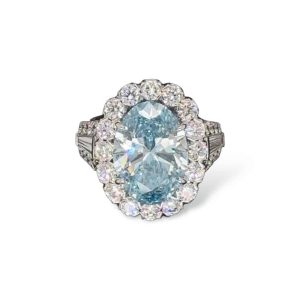 Stunning blue oval-cut gemstone ring with diamond halo and baguette accents.