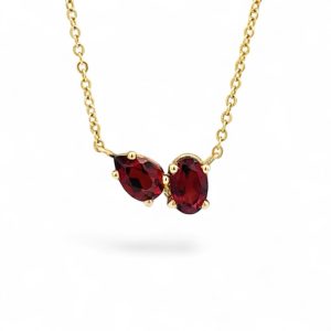 Elegant gold necklace with two pear-shaped red gemstones, perfect for any occasion.