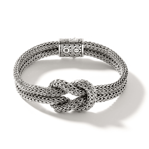 Intricate braided silver bracelet with a central knot symbolizing unity, crafted from sterling silver.