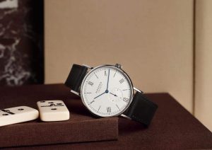 Elegant wristwatch on textured surface with dominoes, showcasing luxury craftsmanship and timeless style.