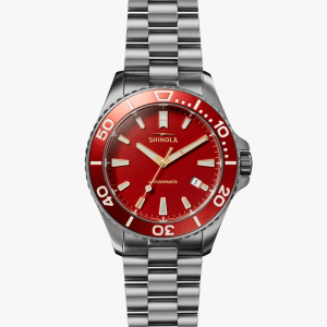 Shinola automatic watch with vibrant red dial, stainless steel case, and stylish bracelet.