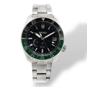 Stylish Seiko GMT watch in stainless steel with black dial and green bezel.