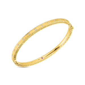 Elegant yellow gold bangle bracelet adorned with diamonds and a hint of ruby charm.